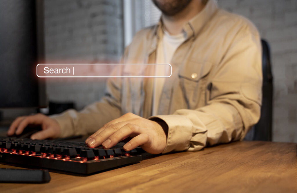 One guy wore cream color shirt and he is typing something in keyboard